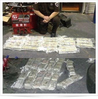 An officer shows the currency found using the CSECO Fiberscope for contraband detection